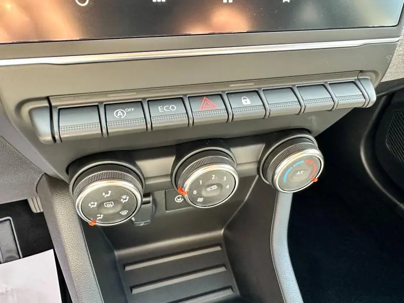 Gros plan sur les commandes de climatisation et boutons de fonction de la Renault Clio blanche, version 2025.