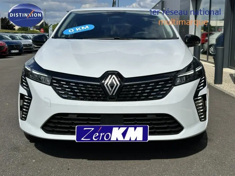 Vue frontale d'une Renault Clio 2025 blanc glacier avec calandre noire et feux LED verticaux allumés.