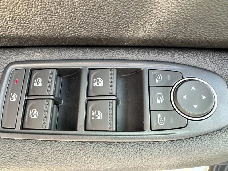 Panneau de commandes des vitres et rétroviseurs côté conducteur dans une Renault Clio 1.5 dCi 100ch Evolution blanc Glacier 2025.