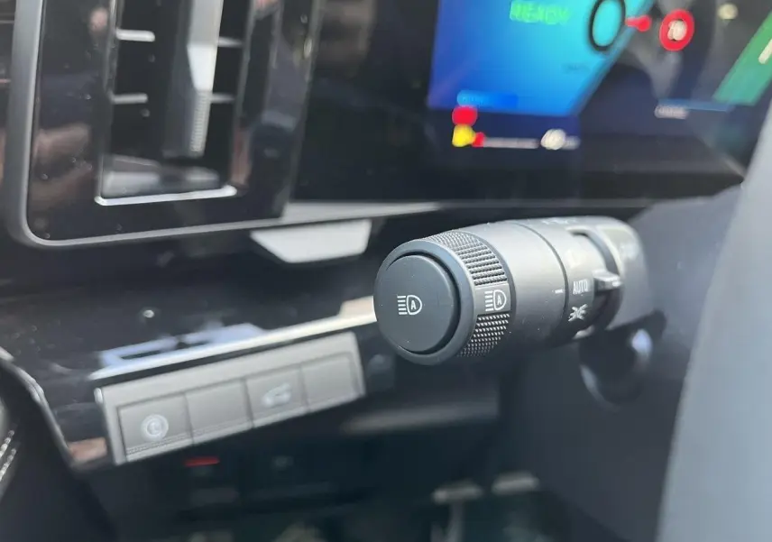 Gros plan sur la commande des feux et l’écran digital du tableau de bord du Renault Austral Ph.2 gris schiste.