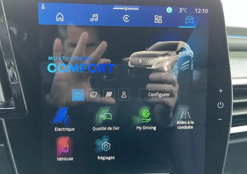 Écran tactile intérieur affichant le menu multimédia avec image du Renault Austral gris schiste en vue 3/4 avant.