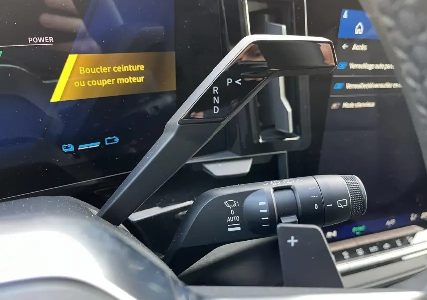 Gros plan sur la commande de boîte automatique et le commodo d’essuie-glace dans l’habitacle du Renault Austral gris schiste.