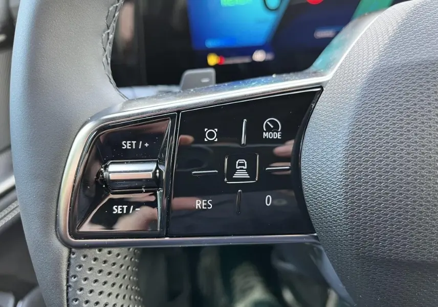 Gros plan sur les commandes gauche au volant du Renault Austral gris schiste, avec boutons de régulateur et mode de conduite.