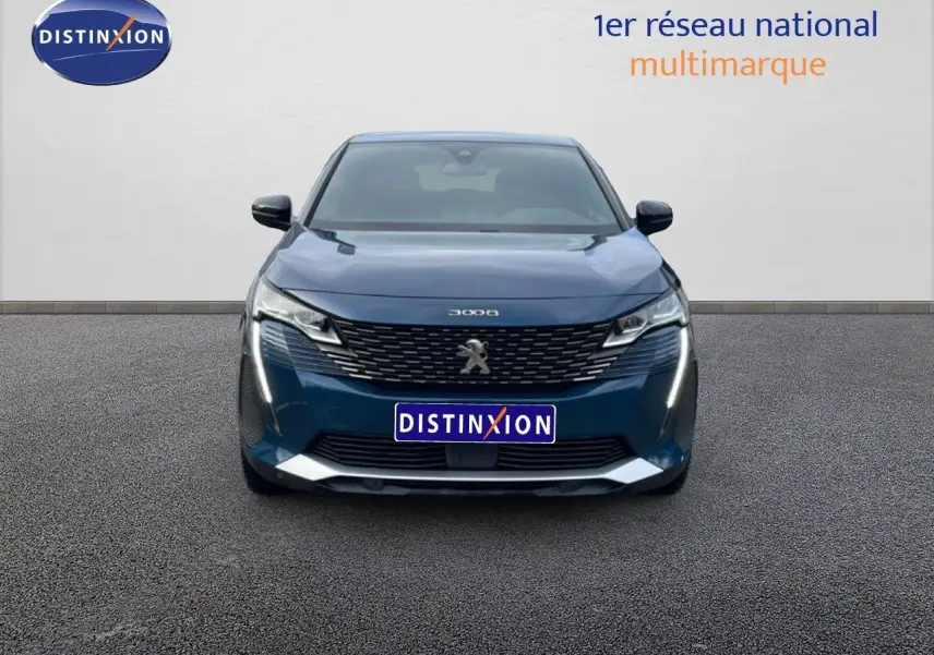 Vue frontale du Peugeot 3008 hybride rechargeable bleu Célèbes Métal avec calandre noire et feux LED verticaux allumés.