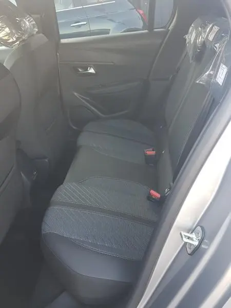 Vue intérieure côté droit des sièges arrière en tissu gris de la Peugeot 208 Hybrid 110 e-DCS6 Allure 2025.