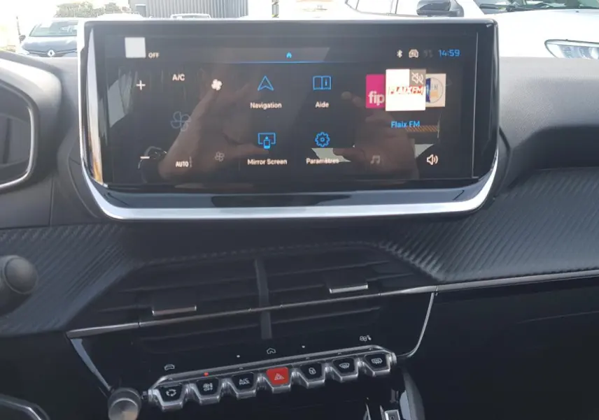 Vue rapprochée de l’écran tactile central et du tableau de bord noir de la Peugeot 208 Hybrid 110 gris, année 2025.