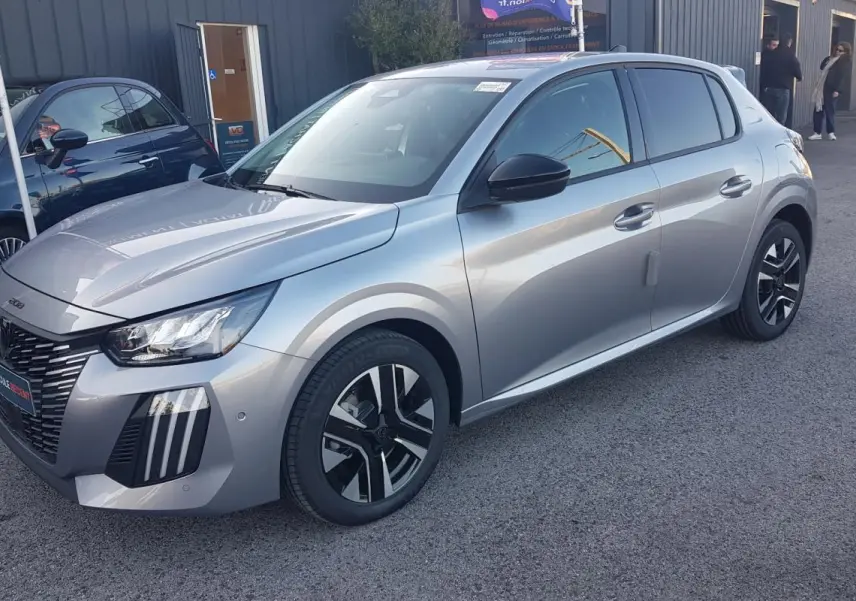 Peugeot 208 Hybrid 110 gris vue 3/4 avant droit, avec jantes alliage noires et calandre distinctive.