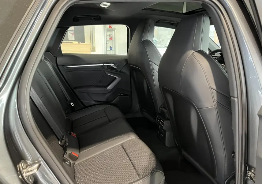 Vue intérieure côté droit de l’Audi A3 Sportback 2025 gris, montrant les sièges arrière en cuir noir et les ports USB arrière.