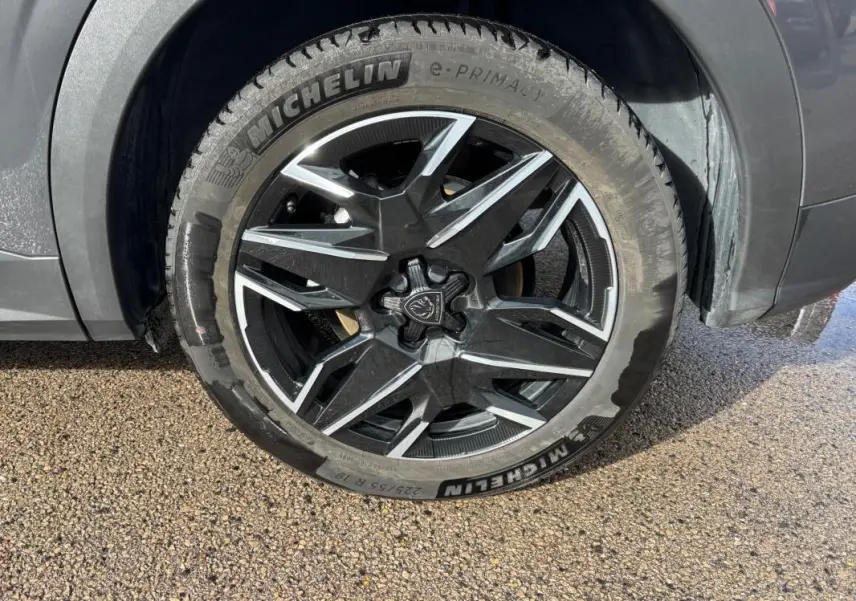 Gros plan sur la jante alliage 19 pouces noire et argentée du côté avant droit du Peugeot 3008 gris 2025.