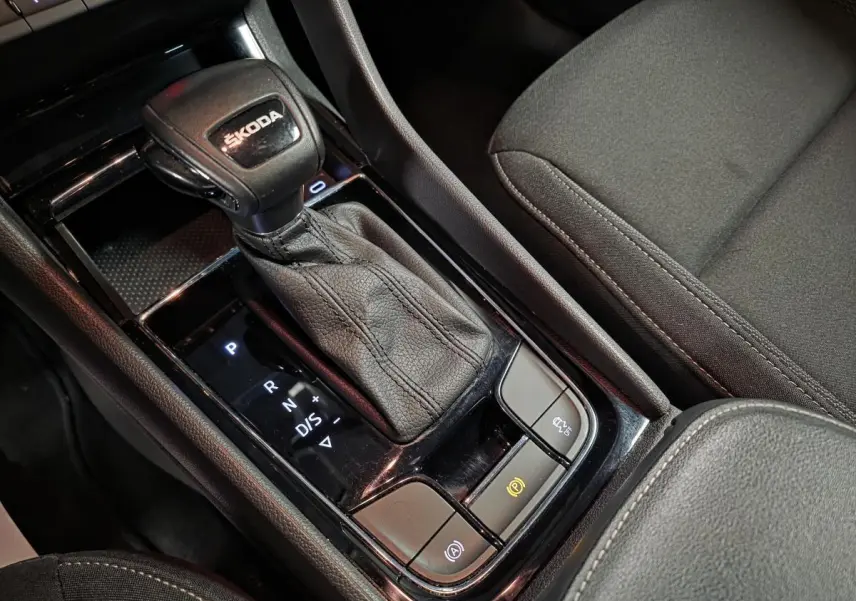 Gros plan sur la console centrale intérieure du Skoda Karoq 2024 avec levier de vitesse automatique en cuir noir.