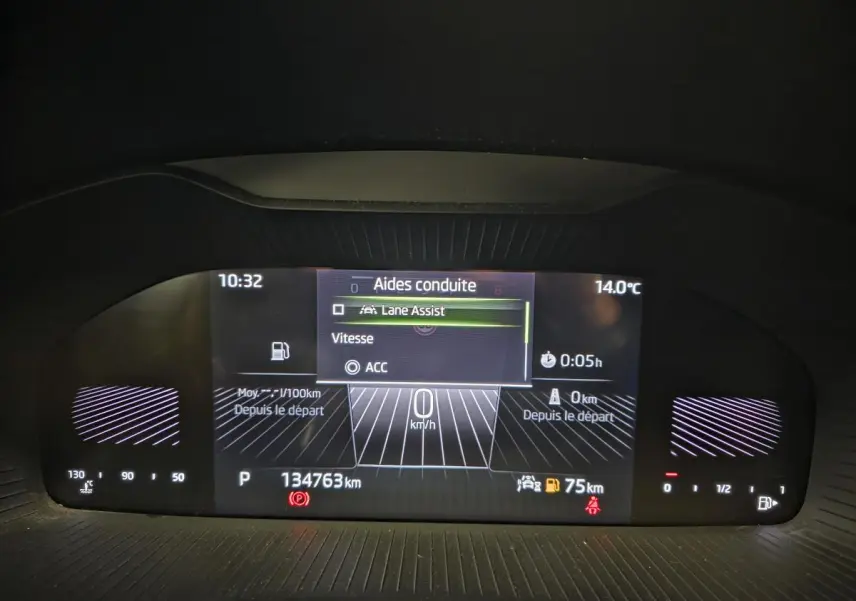 Affichage numérique du tableau de bord du Skoda Karoq bleu, montrant les aides à la conduite et la vitesse à 0 km/h.