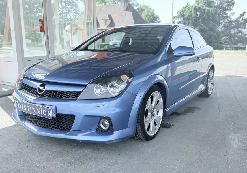 Opel Astra OPC bleu vue 3/4 avant droit, avec jantes alliage et calandre noire ajourée.