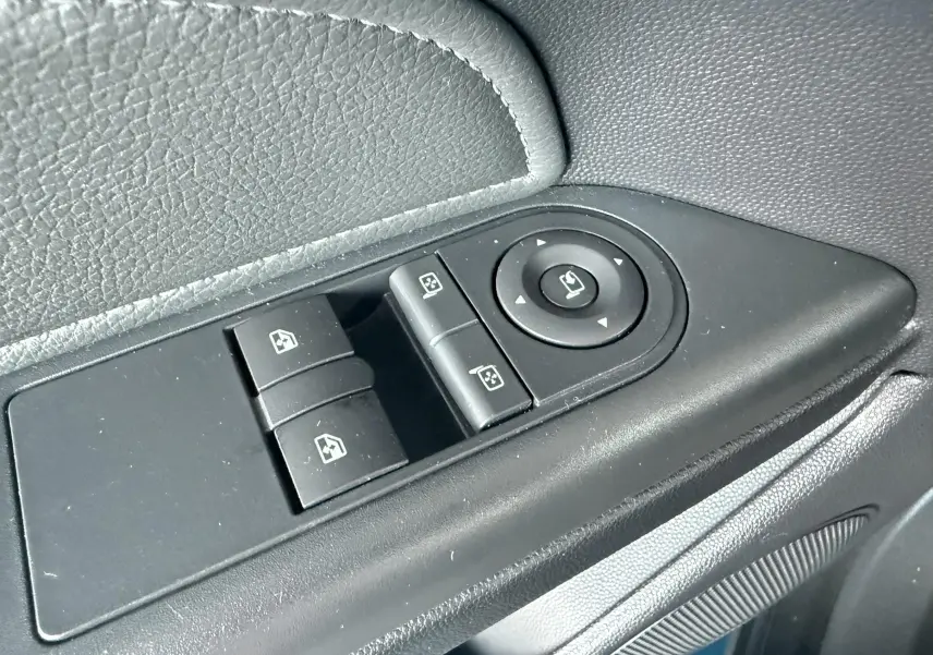 Gros plan sur les commandes de lève-vitres et réglage des rétroviseurs côté conducteur de l’Opel Astra OPC 2008.