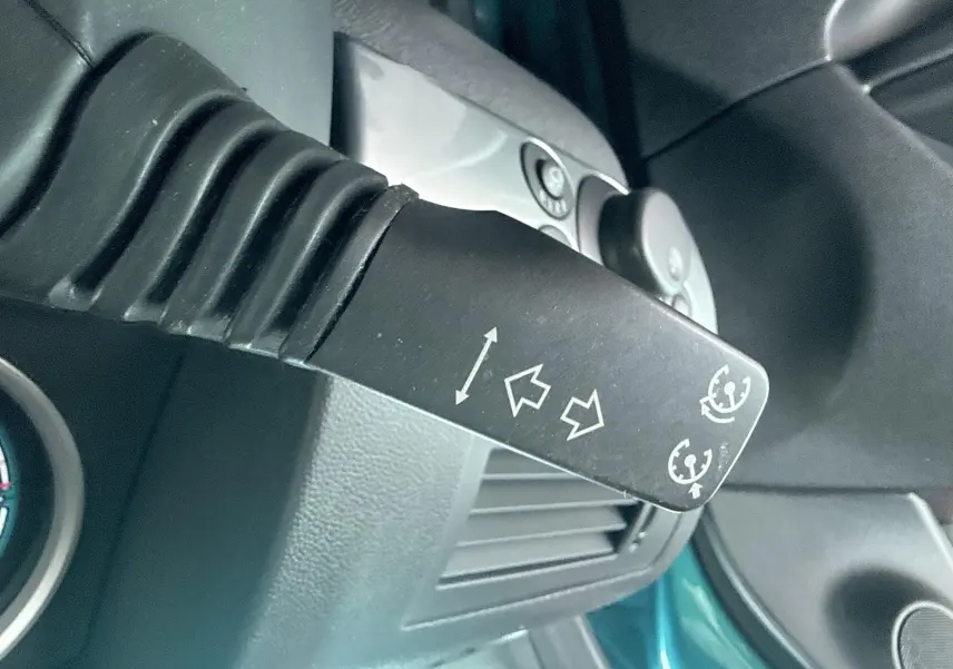 Gros plan sur la commande de clignotant et régulateur de vitesse dans l’habitacle d’une Opel Astra OPC bleu.