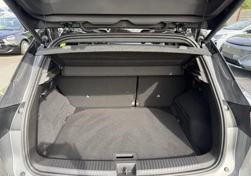 Coffre ouvert vue arrière du Renault Austral gris Schiste satin avec intérieur noir et cache-bagages déployé.