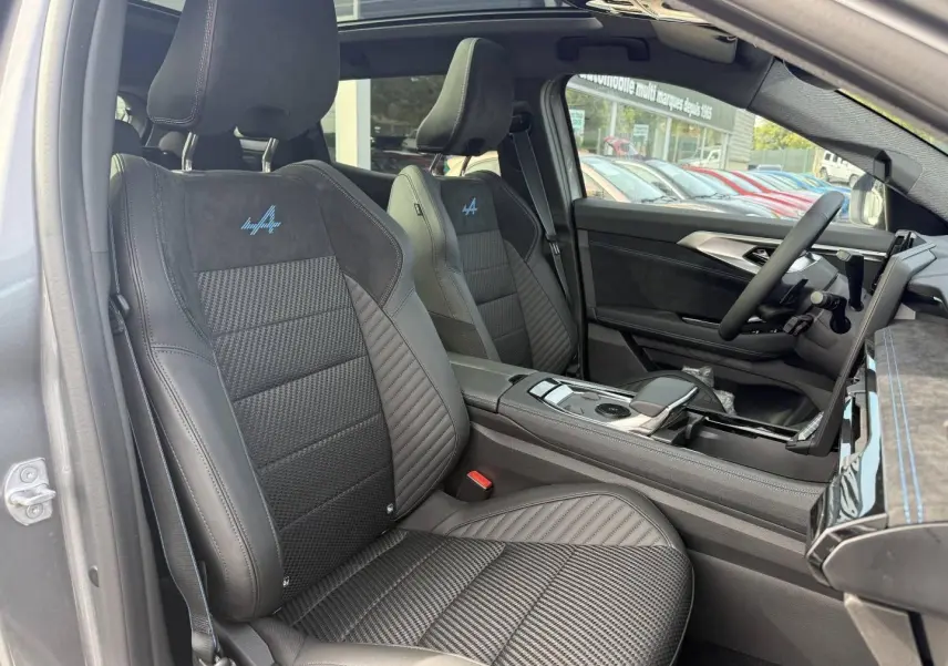 Vue intérieure côté conducteur du Renault Austral gris avec sièges sport en cuir et Alcantara esprit Alpine brodés bleu.