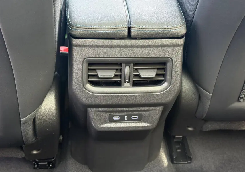 Vue rapprochée des aérateurs arrière et ports USB-C noirs sur la console centrale du Renault Austral gris Schiste satin.