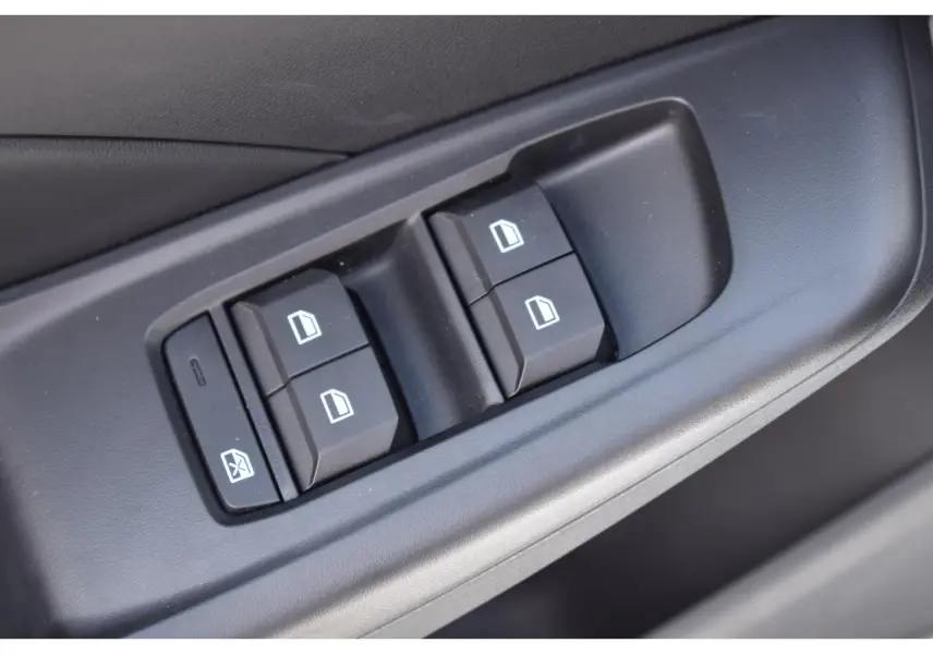 Gros plan sur les commandes des vitres électriques côté conducteur du MG MOTOR MG3 blanc 2026 hybride.
