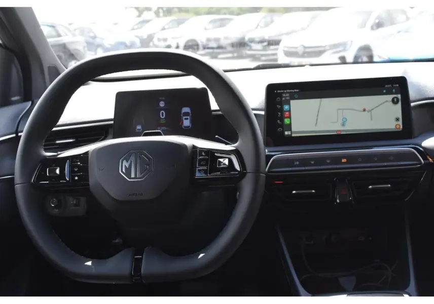 Vue intérieure centrée sur le volant noir du MG3 1.5 HYBRID+ 195 LUXURY avec tableau de bord numérique et écran tactile.