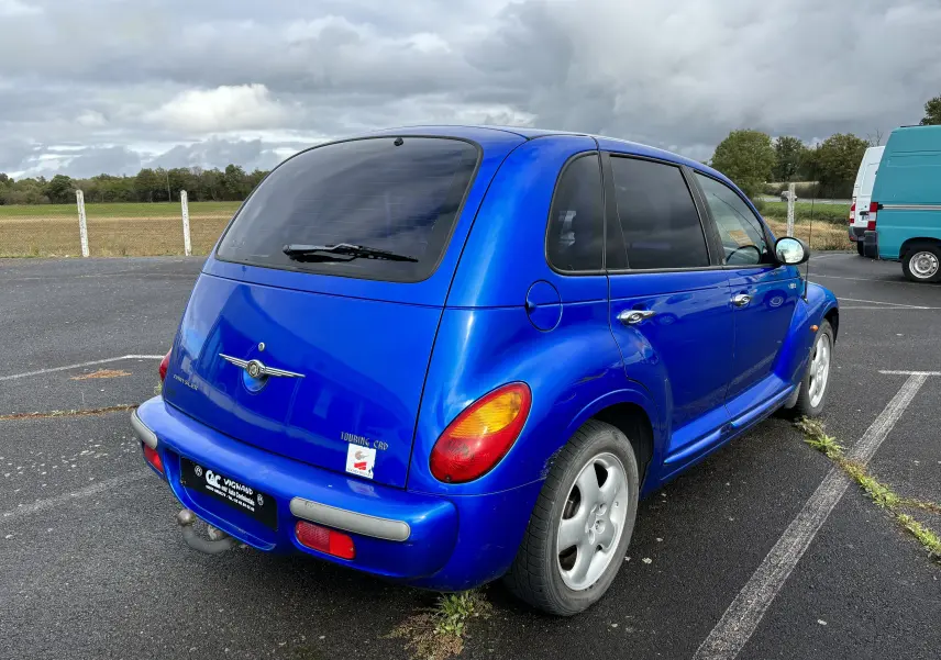 Vue 3/4 arrière droite d'une Chrysler PT Cruiser bleu vif de 2004 avec feux arrière ovales et hayon teinté.