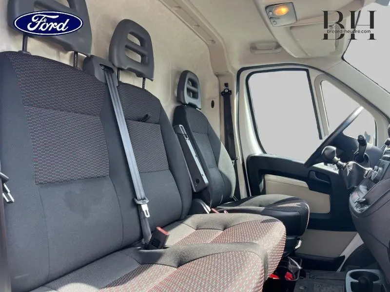 Vue intérieure côté conducteur du Citroën Jumper blanc Banquise, montrant la banquette avant 3 places et le tableau de bord.