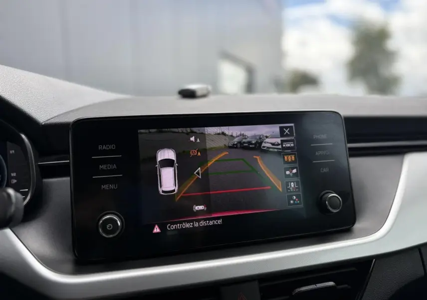 Écran tactile du tableau de bord du Skoda Kamiq rouge montrant la caméra de recul avec guidage dynamique.