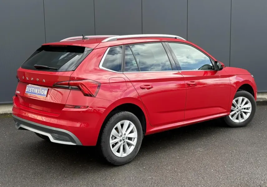 Vue 3/4 arrière droite d'un Skoda Kamiq 2024 rouge Velvet avec vitres arrière surteintées et jantes alliage 16 pouces.
