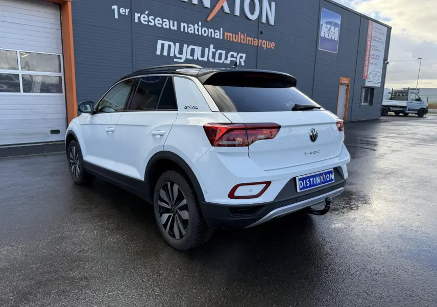 Vue 3/4 arrière droite du Volkswagen T-Roc blanc pur avec attelage amovible et jantes alliage Zürich 17 pouces.