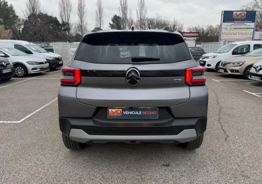 Vue arrière d'une Citroën C3 gris 2025 avec feux LED distinctifs et barres de toit visibles en parking.
