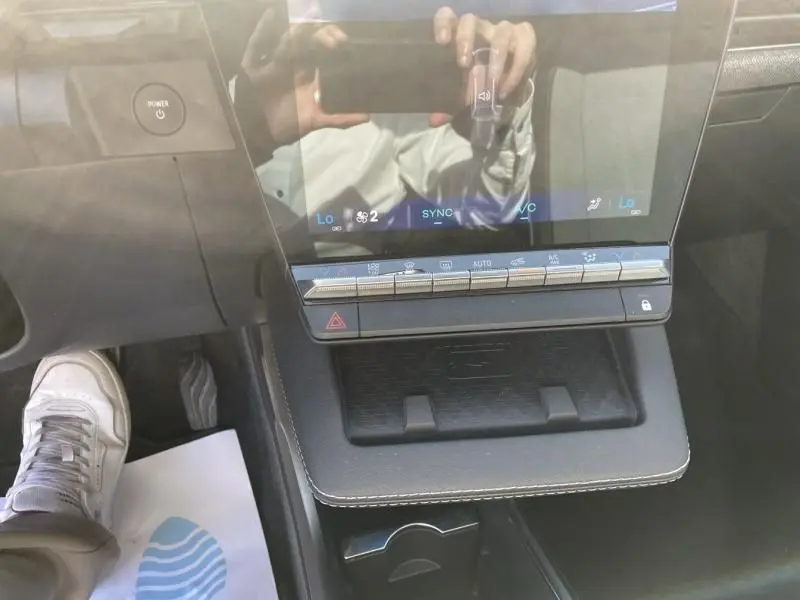 Vue intérieure centrée sur la console centrale tactile du Renault Scénic E-Tech 2024, avec commandes climatisation et bouton Power.