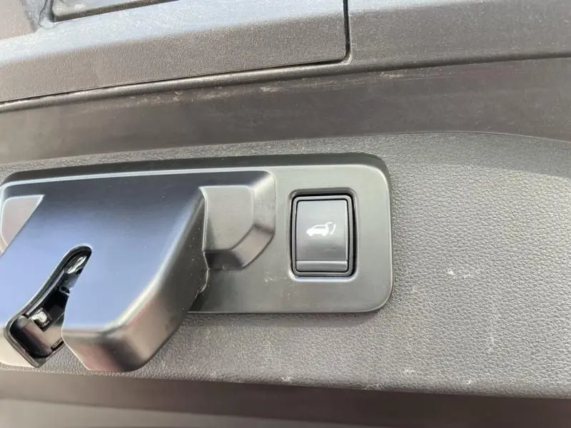 Bouton d'ouverture électrique du coffre sur la garniture intérieure d'un Renault Scenic E-Tech 2024.