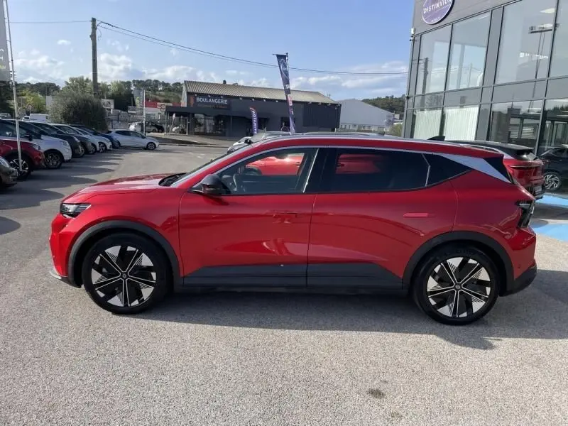 Profil droit du Renault Scénic E-Tech électrique 2024 en rouge flamme avec jantes noires et toit contrasté gris.