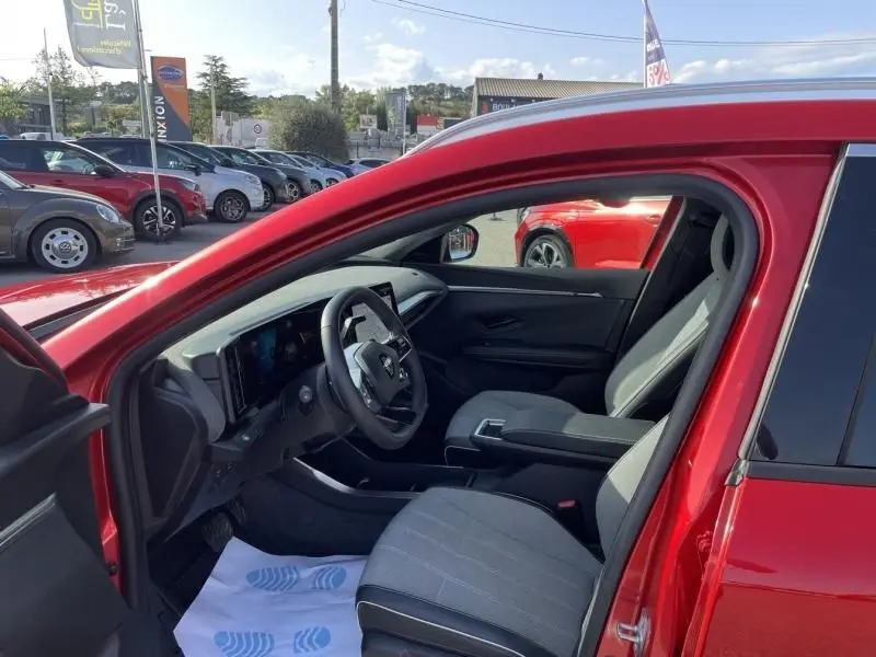 Intérieur côté conducteur du Renault Scénic E-Tech Rouge Flamme 2024, avec tableau de bord numérique et sièges gris.