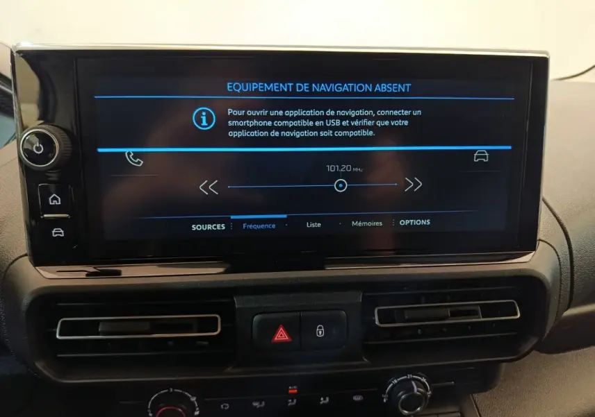 Vue intérieure centrée sur l'écran tactile du tableau de bord du Peugeot Partner blanc, affichant un message d'absence de navigation.