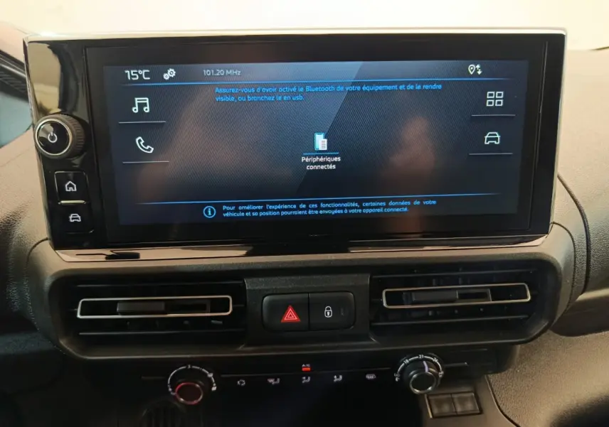 Écran tactile central et commandes de climatisation du tableau de bord du Peugeot Partner 2025, intérieur noir.