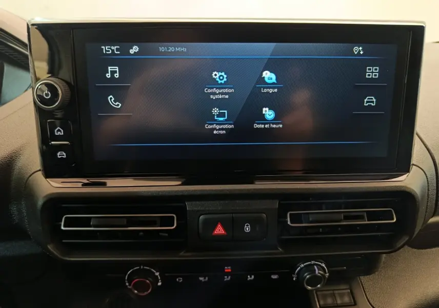 Écran tactile central du tableau de bord du Peugeot Partner 2025 avec commandes de climatisation et boutons d’alerte visibles.