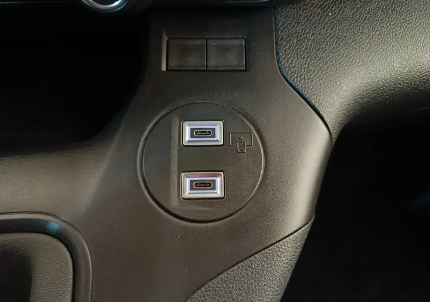 Gros plan sur deux ports USB-C intégrés dans la console centrale noire du Peugeot Partner blanc 2025.