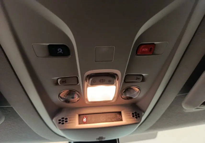 Vue intérieure du plafonnier du Peugeot Partner blanc 2025 avec éclairage central et bouton SOS rouge.