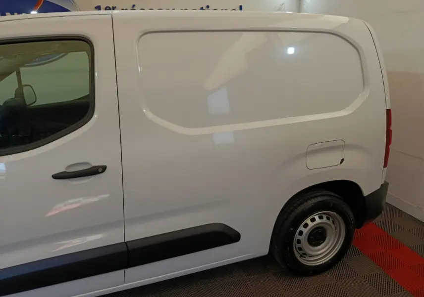 Vue latérale droite d'un utilitaire Peugeot Partner blanc, version Taille M, avec porte latérale pleine et jante acier simple.