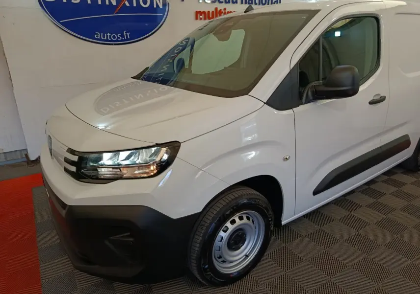 Vue 3/4 avant droit du Peugeot Partner blanc 2025 avec pare-chocs noir et jante acier simple.