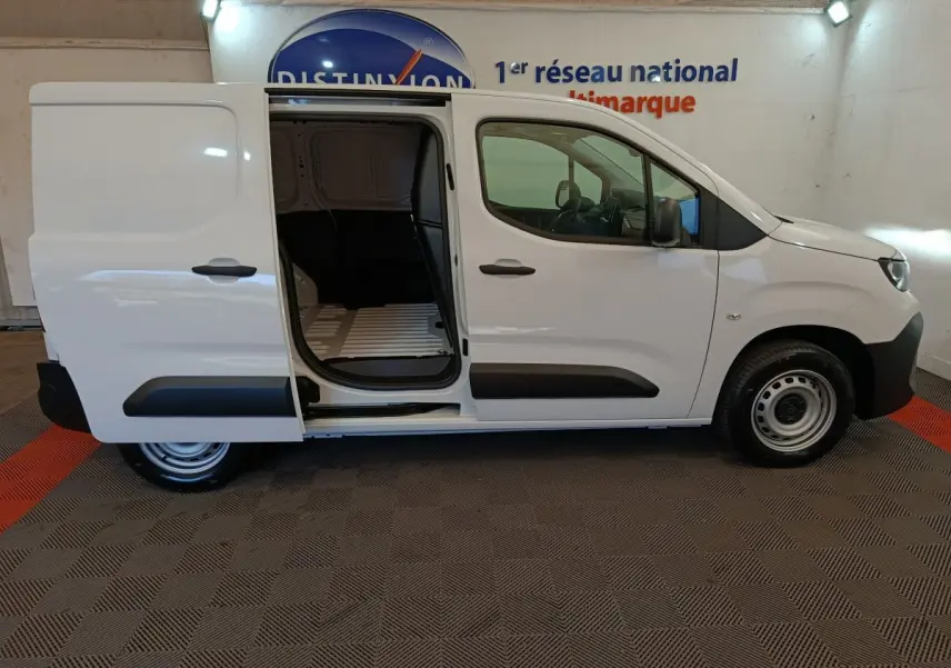 Vue latérale droite d'un Peugeot Partner blanc 2025 avec porte coulissante ouverte montrant l'espace de chargement.