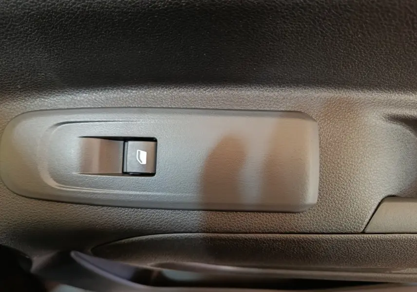 Gros plan sur l'interrupteur de lève-vitre électrique côté conducteur du Peugeot Partner blanc 2025.
