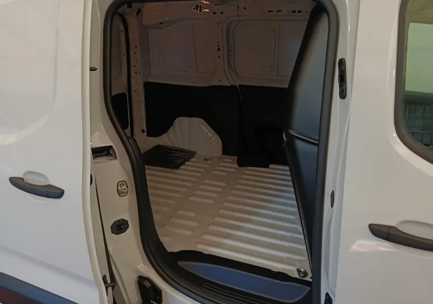 Vue intérieure du coffre blanc du Peugeot Partner Taille M 650kg, montrant l'espace de chargement vide avec cloison pleine.