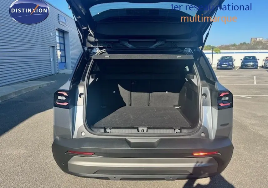 Vue arrière du Jeep Compass gris Yosemite avec coffre ouvert, toit noir visible, sur parking extérieur ensoleillé.