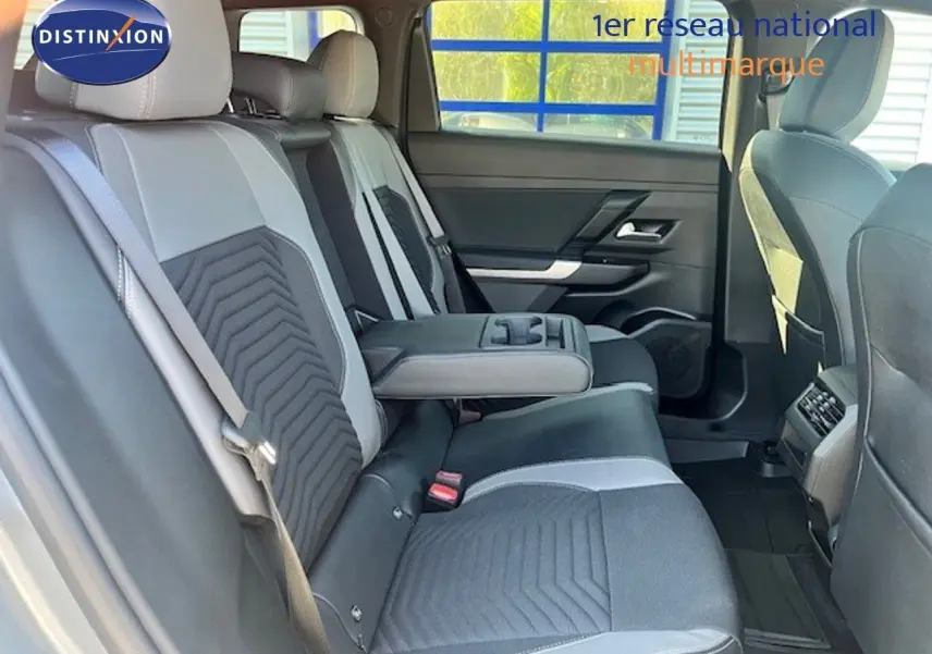 Vue intérieure arrière du Jeep Compass 2026, sièges bicolores gris clair et foncé avec accoudoir central déployé.