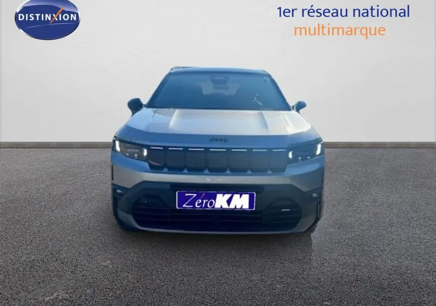 Vue frontale d'un Jeep Compass 2026 gris Yosemite métal avec toit noir, calandre noire et feux LED allumés.