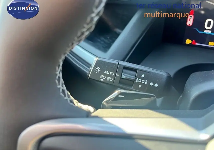 Gros plan sur la commande des feux et clignotants du Jeep Compass 2026, intérieur noir avec volant cuir.