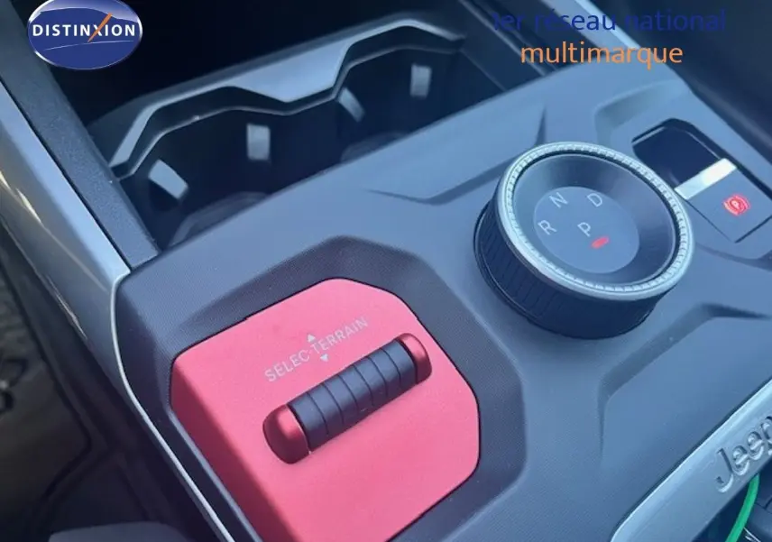 Gros plan sur la console centrale du Jeep Compass 2026, avec molette de boîte auto et sélecteur de terrain rouge.