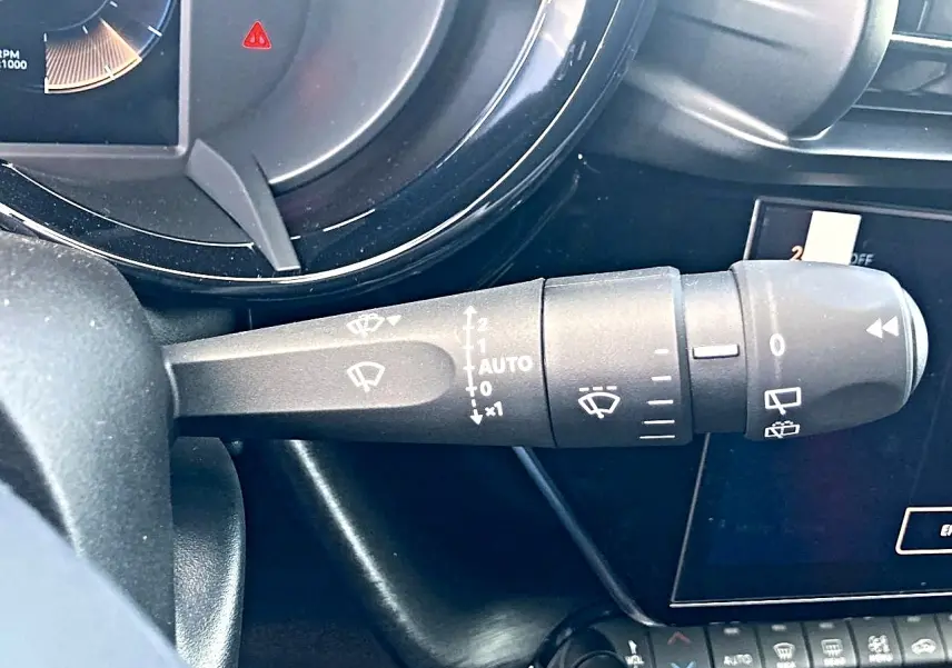 Gros plan sur la manette d'essuie-glace côté gauche du tableau de bord de l'Alfa Romeo Junior gris 2026.