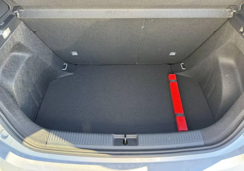 Coffre ouvert vu de dessus d'une MG3 Cosmic Silver, avec tapis noir et triangle de signalisation rouge.